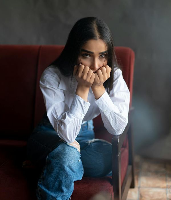 A person in a calm, seated stretching pose, outlined in a saffron color.